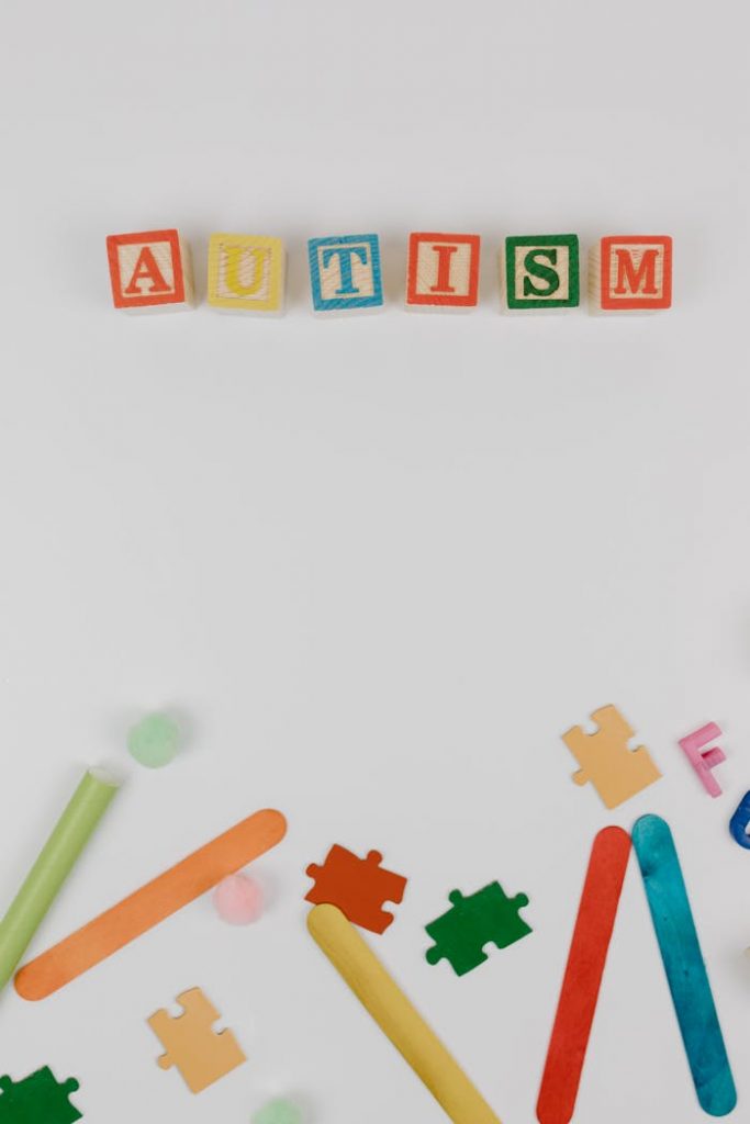 Colorful autism awareness display with blocks and puzzle pieces on a white background.